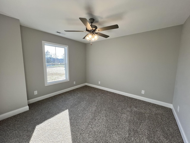 spare room with dark colored carpet and ceiling fan