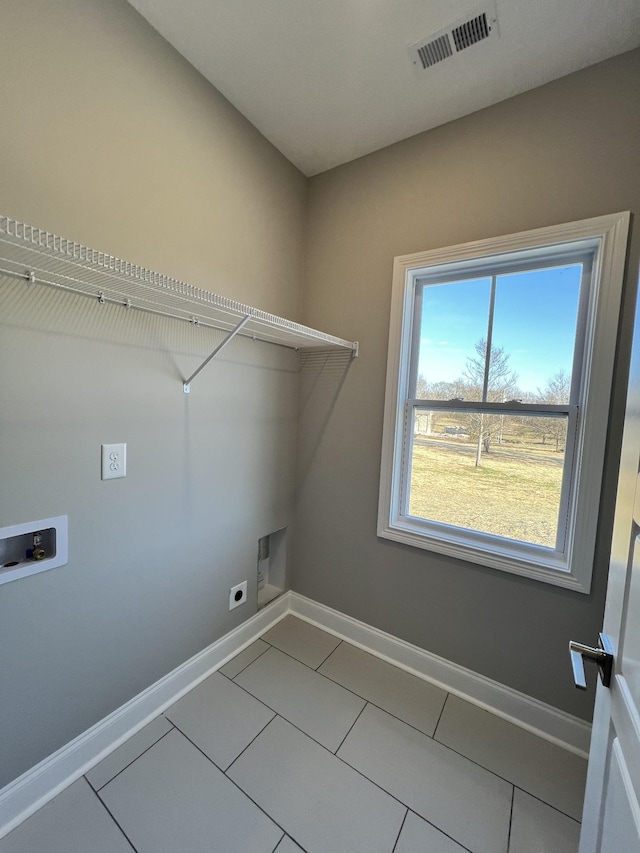 laundry room with electric dryer hookup, hookup for a washing machine, a healthy amount of sunlight, and tile patterned flooring