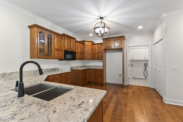 kitchen with sink, hanging light fixtures, an inviting chandelier, light stone counters, and ornamental molding