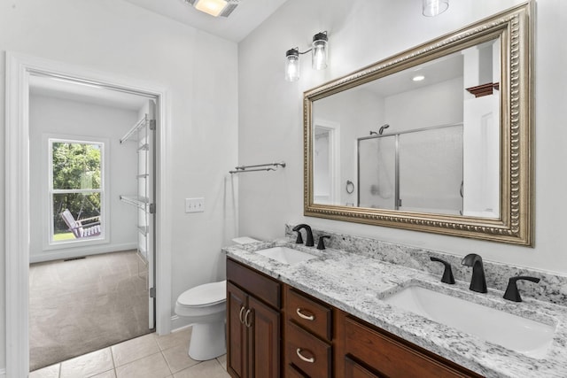 bathroom with tile patterned floors, toilet, vanity, and walk in shower