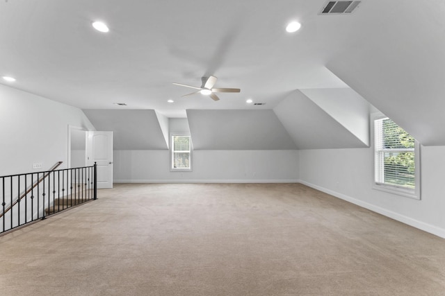 additional living space with light colored carpet, ceiling fan, and lofted ceiling