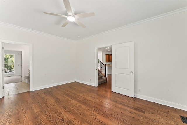 unfurnished room with ceiling fan, crown molding, and dark wood-type flooring