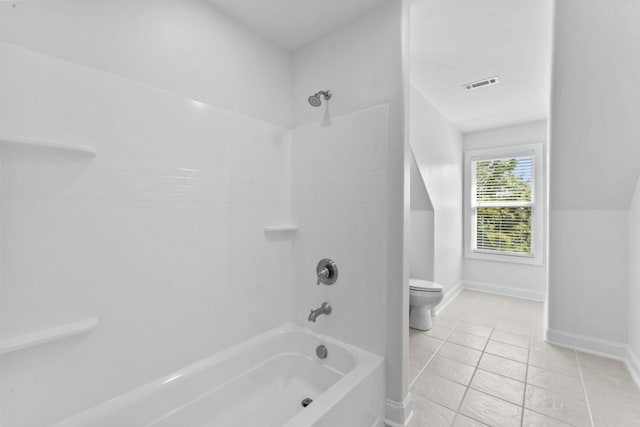 bathroom featuring washtub / shower combination, tile patterned flooring, and toilet