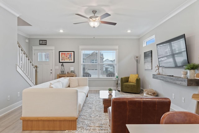 living room with ceiling fan, light wood-type flooring, and ornamental molding