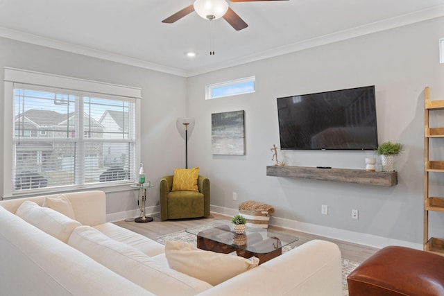 living room featuring light hardwood / wood-style flooring, a healthy amount of sunlight, and ornamental molding