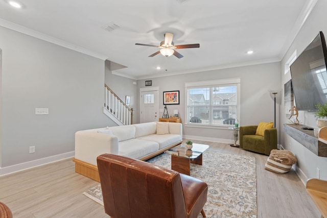 living room with ceiling fan, ornamental molding, and light wood-type flooring