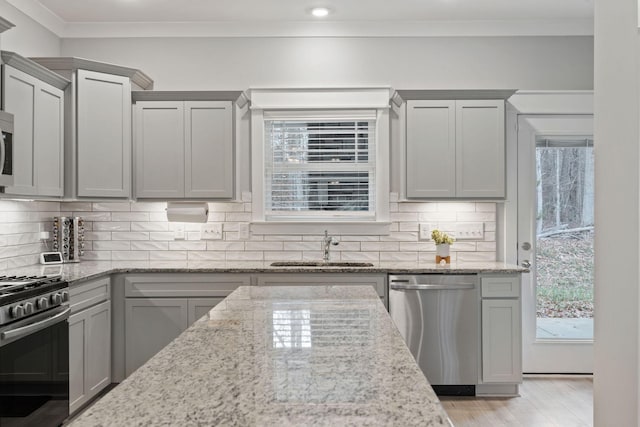 kitchen with gray cabinets, light stone counters, sink, and appliances with stainless steel finishes