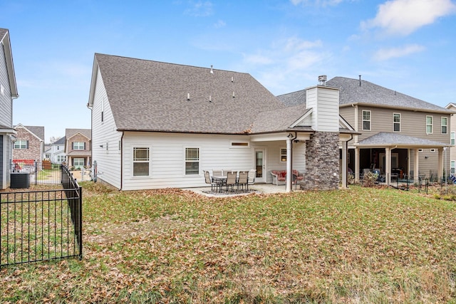 rear view of house with a yard, central AC unit, and a patio area