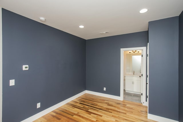 spare room featuring sink and light wood-type flooring