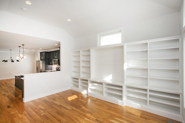 empty room with wood-type flooring and vaulted ceiling