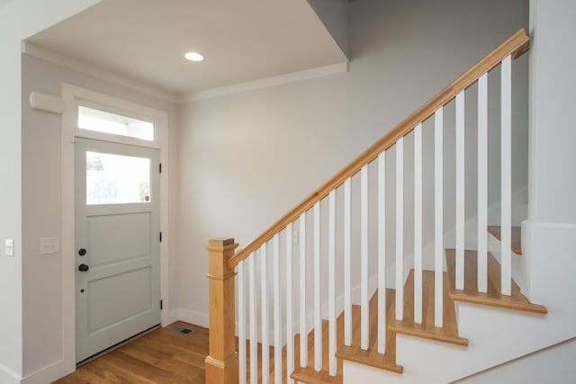 foyer with crown molding and hardwood / wood-style floors