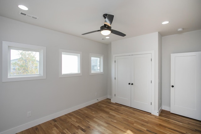 unfurnished bedroom featuring hardwood / wood-style flooring, ceiling fan, and a closet