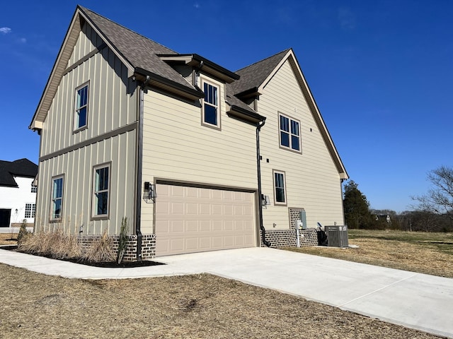 view of side of property featuring a garage and cooling unit