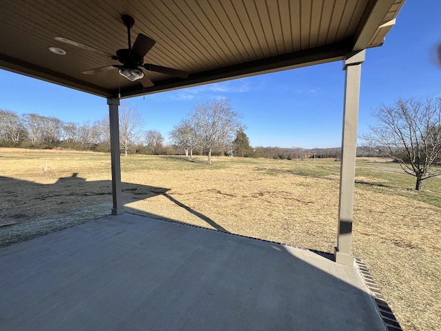 view of yard featuring ceiling fan, a rural view, and a patio