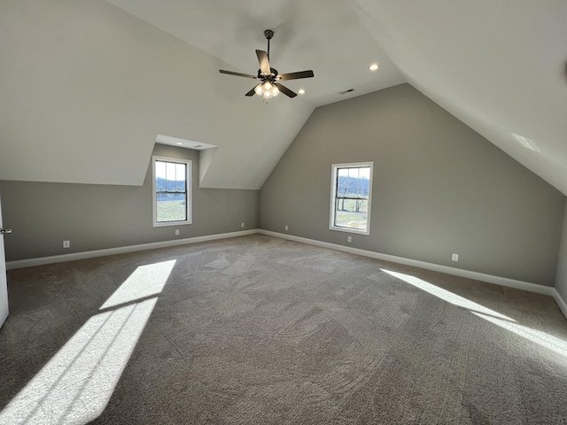 additional living space featuring ceiling fan, dark carpet, and lofted ceiling