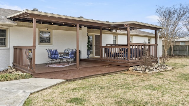 rear view of house featuring a lawn and a deck