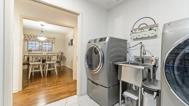 washroom with hardwood / wood-style flooring and washer / clothes dryer