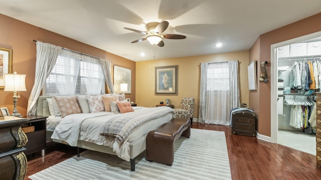 bedroom with multiple windows, ceiling fan, a closet, and dark hardwood / wood-style floors