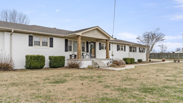 ranch-style home featuring covered porch and a front yard