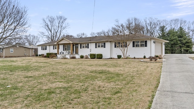 ranch-style home featuring covered porch, a front yard, and a garage