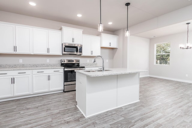 kitchen featuring sink, white cabinets, hanging light fixtures, and appliances with stainless steel finishes