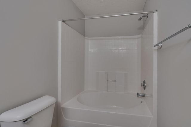 bathroom with toilet, a textured ceiling, and washtub / shower combination