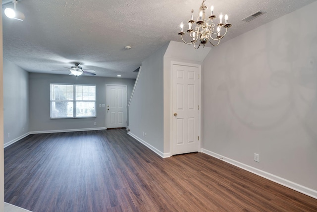 unfurnished room featuring a textured ceiling, dark hardwood / wood-style floors, lofted ceiling, and ceiling fan with notable chandelier