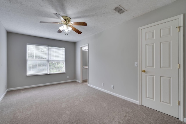 spare room with light carpet, a textured ceiling, and ceiling fan