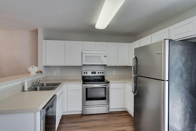 kitchen featuring sink, stainless steel appliances, dark hardwood / wood-style floors, a textured ceiling, and white cabinets