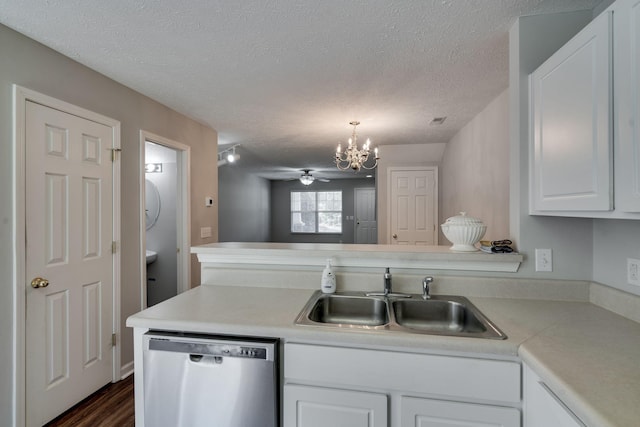 kitchen with stainless steel dishwasher, ceiling fan with notable chandelier, sink, pendant lighting, and white cabinets