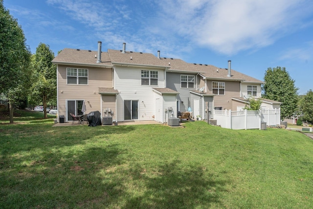 back of house featuring central AC unit and a yard