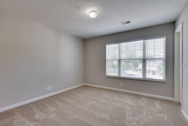 empty room featuring a textured ceiling and light carpet