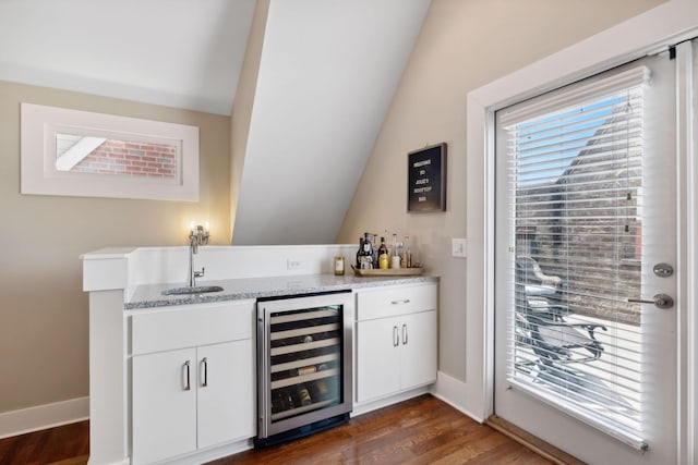 bar with white cabinets, sink, vaulted ceiling, dark hardwood / wood-style flooring, and beverage cooler