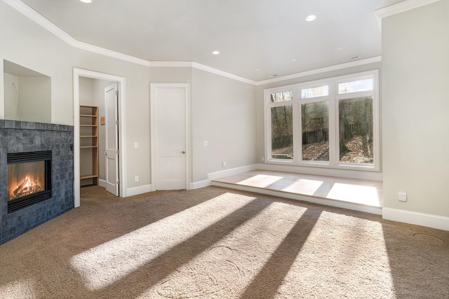 unfurnished living room featuring carpet, crown molding, and a tiled fireplace