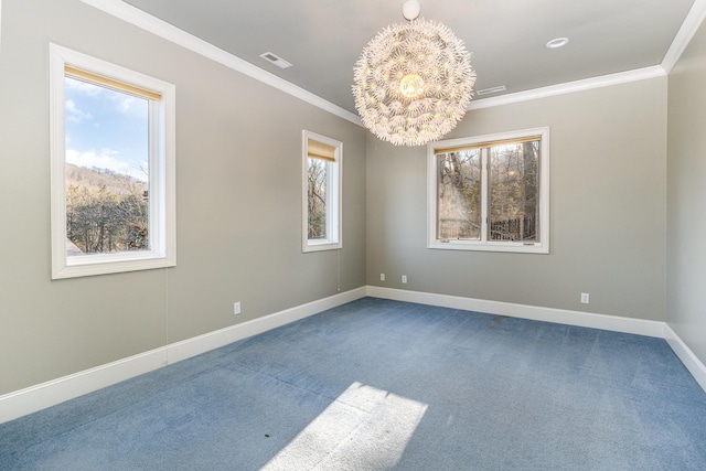 carpeted spare room featuring ornamental molding, an inviting chandelier, and a healthy amount of sunlight