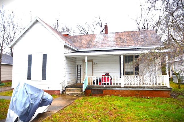 view of front of home with a porch and a front yard