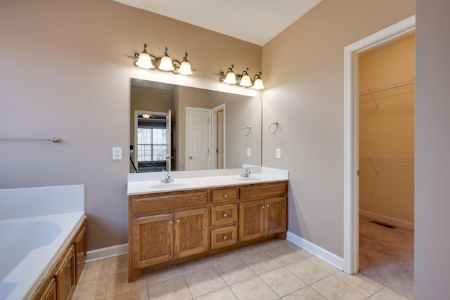 bathroom featuring tile patterned flooring, vanity, and a tub