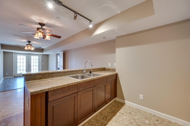 kitchen with track lighting, french doors, sink, ceiling fan, and kitchen peninsula