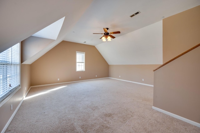 additional living space featuring ceiling fan, light colored carpet, and vaulted ceiling