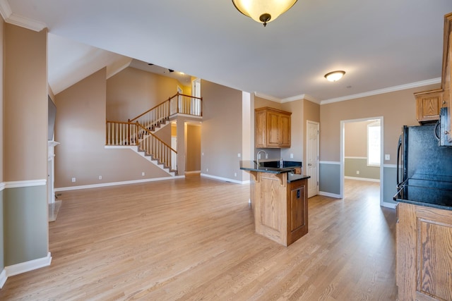 kitchen featuring kitchen peninsula, a kitchen breakfast bar, vaulted ceiling, crown molding, and light hardwood / wood-style flooring