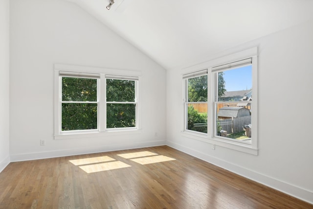 unfurnished room featuring wood-type flooring and lofted ceiling