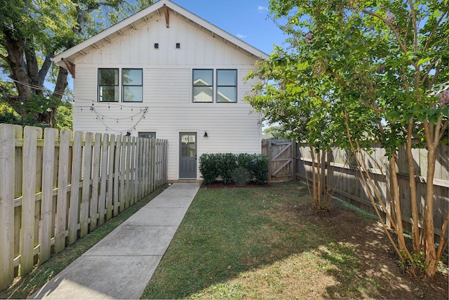 rear view of property featuring a lawn