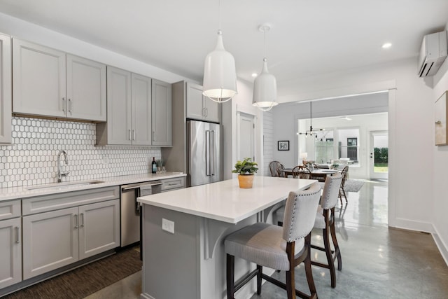 kitchen featuring gray cabinetry, sink, stainless steel appliances, and decorative light fixtures