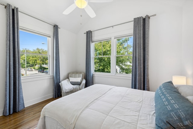 bedroom featuring multiple windows, ceiling fan, wood-type flooring, and lofted ceiling