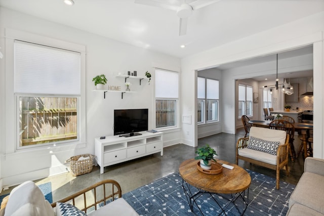 living room with ceiling fan with notable chandelier