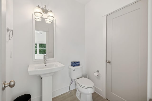 bathroom featuring hardwood / wood-style flooring, toilet, and sink