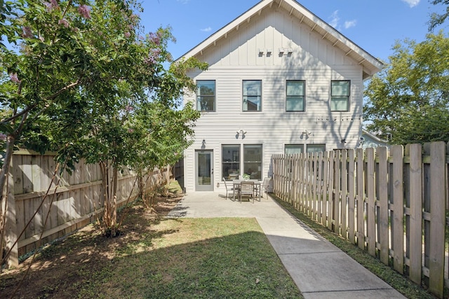 back of house featuring a lawn and a patio