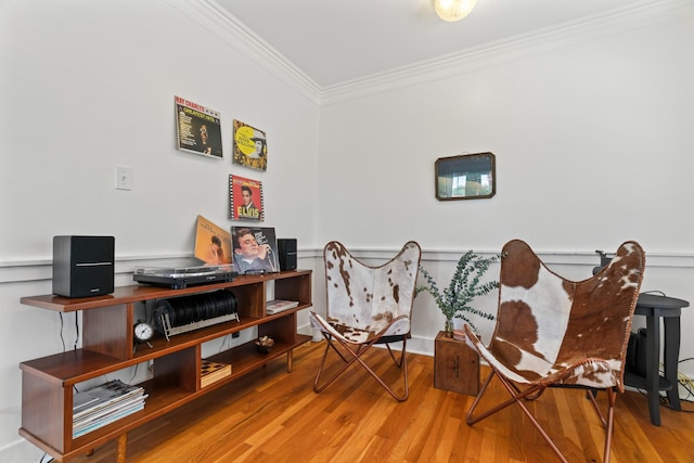 living area featuring hardwood / wood-style floors and ornamental molding