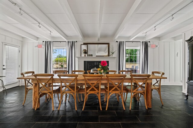 dining space featuring beamed ceiling and track lighting