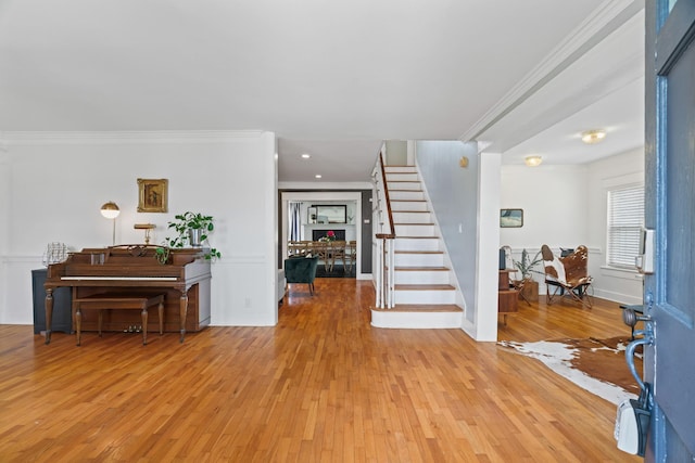 entryway with light hardwood / wood-style floors and ornamental molding